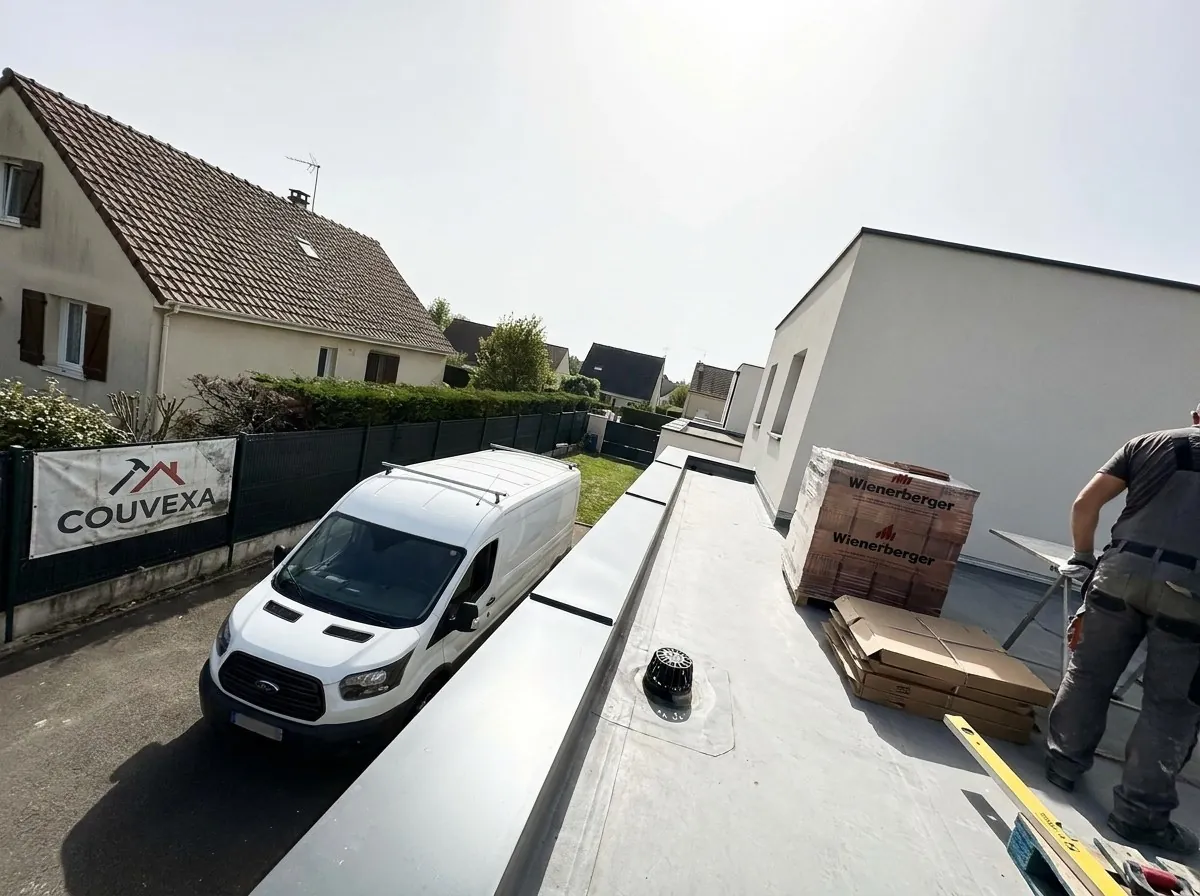 Toit plat d’un pavillon d’Évry-Courcouronnes avec acrotère, couvertine et évacuation, bâche Couvexa sur la clôture et pavillon en tuiles voisin