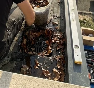 Évacuation de toit plat encombrée de feuilles mortes, en cours de nettoyage par Couvexa à Évry-Courcouronnes